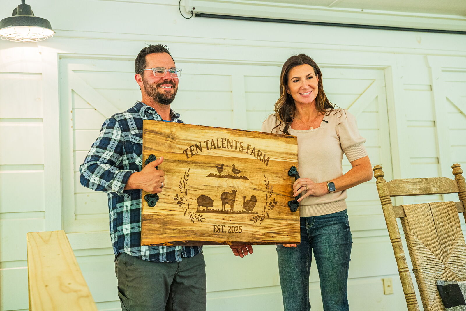 The Nortons holding the Ten Talents Farm sign